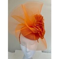 Orange fascinator with crin waves with a large flower